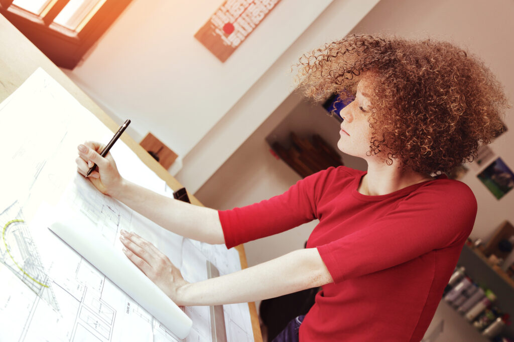 jeune étudiante en architecture travaillant dans bureau Baufirma Bauauftrag Zuschlag